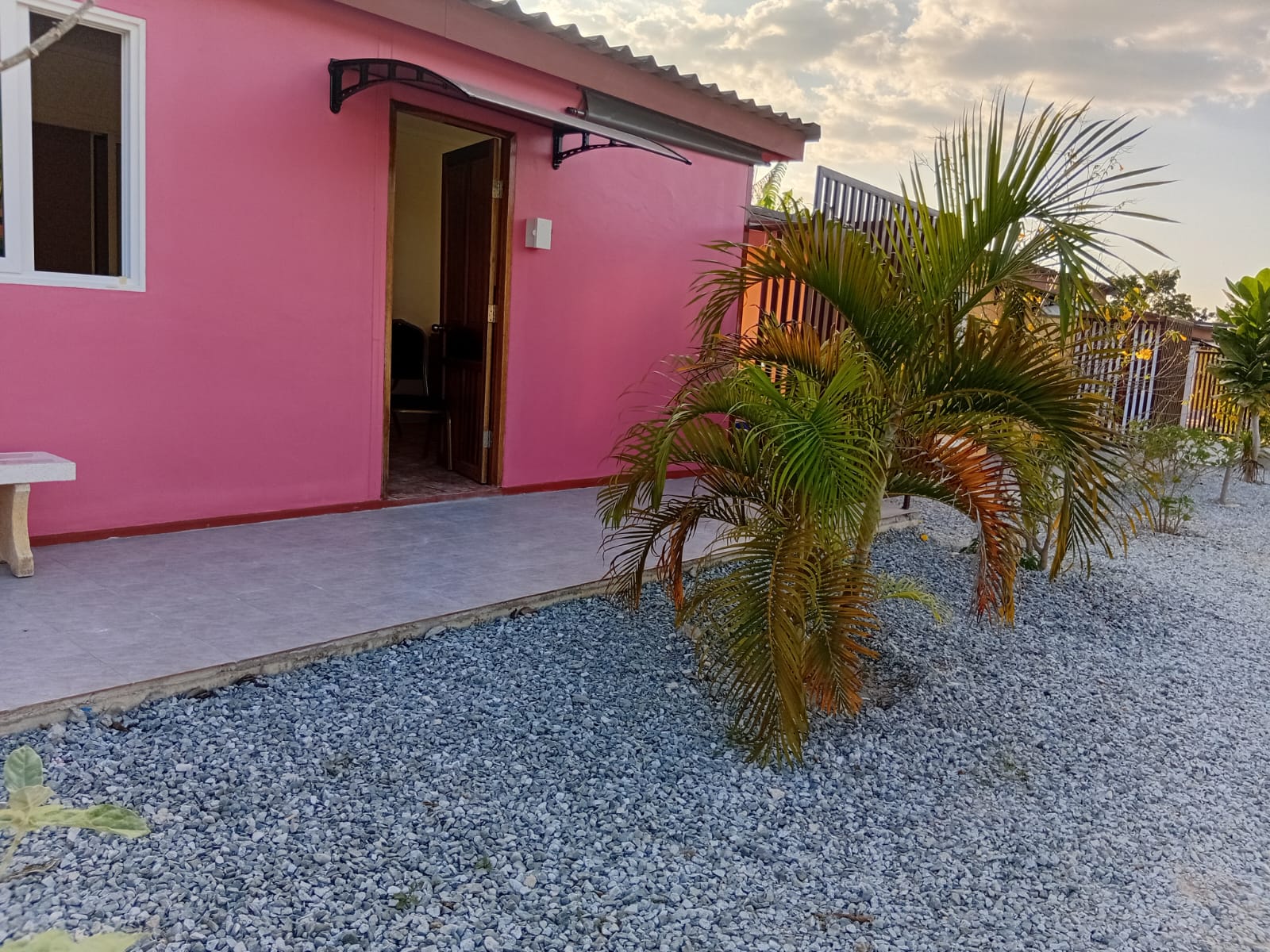 Rosa Bungalow mit Pflanzen davor
